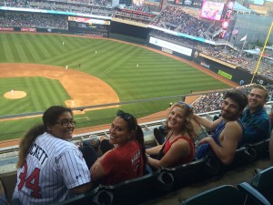 crowd watching a game at Target Field. Baseball fans turn to smile at camera